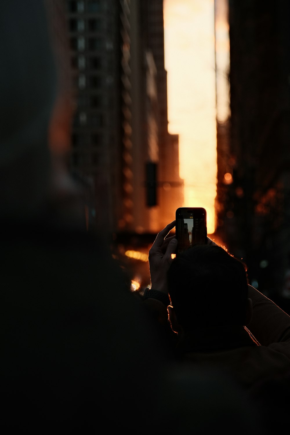 a person taking a picture of a city at sunset