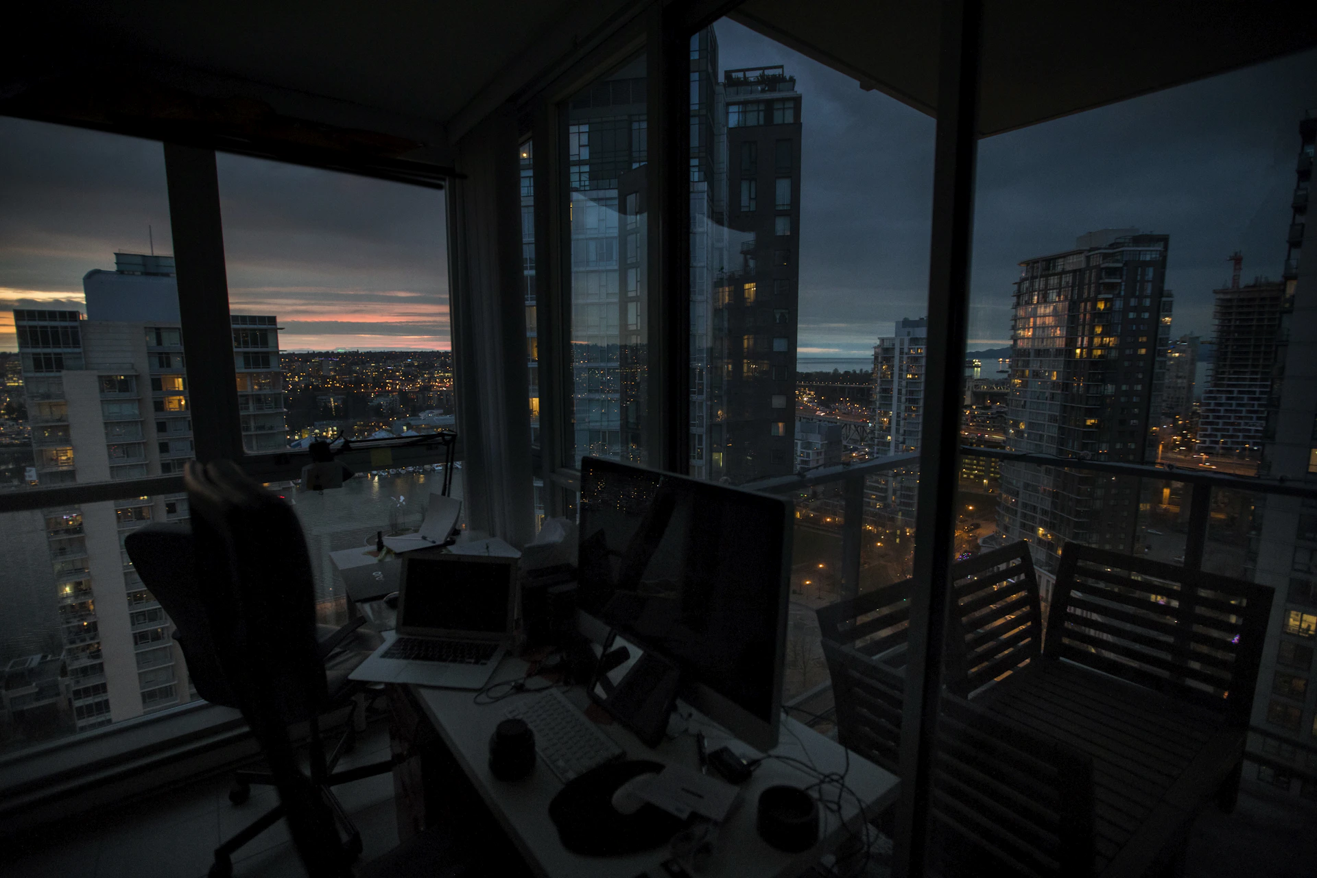 a desk with a computer on top of it in front of a window