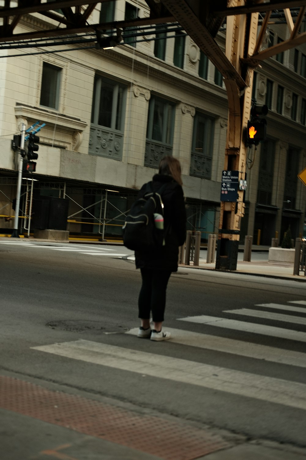 a woman crossing the street at an intersection