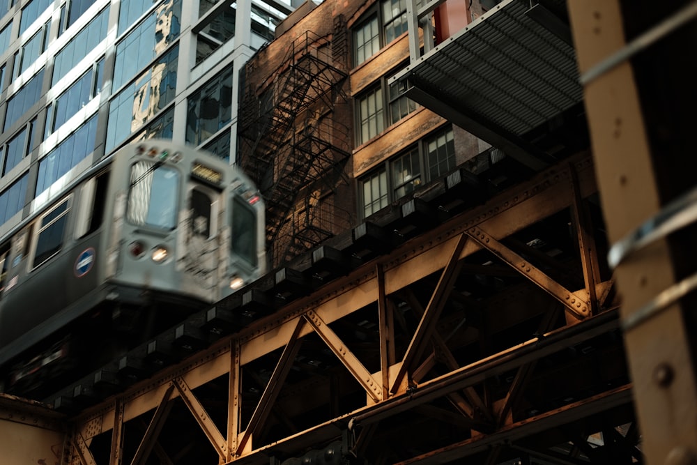 a train traveling over a bridge next to tall buildings