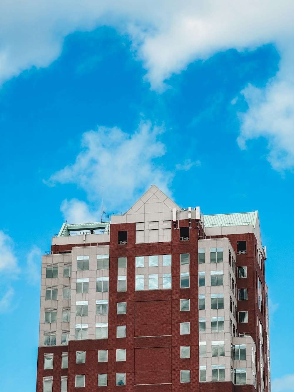a tall red brick building sitting under a blue sky