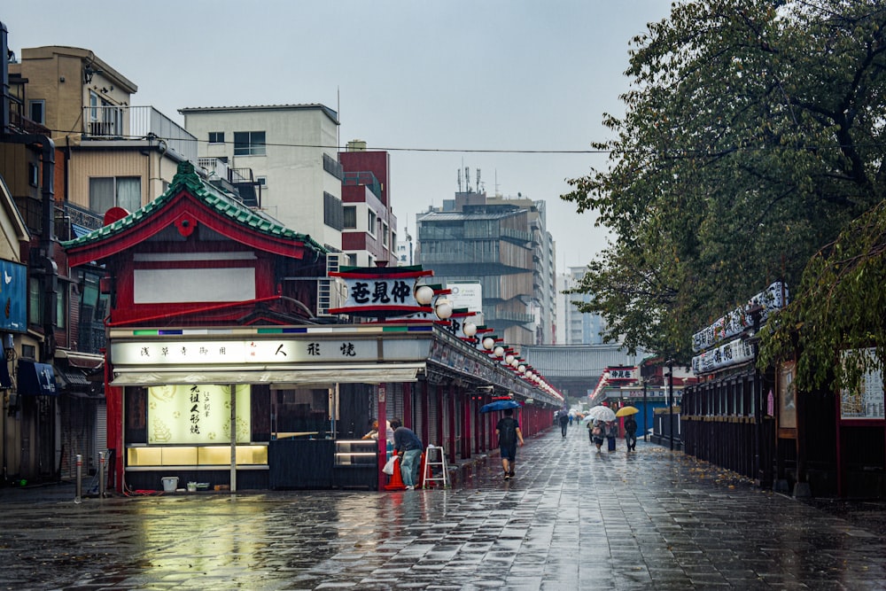 a wet street with people walking down it