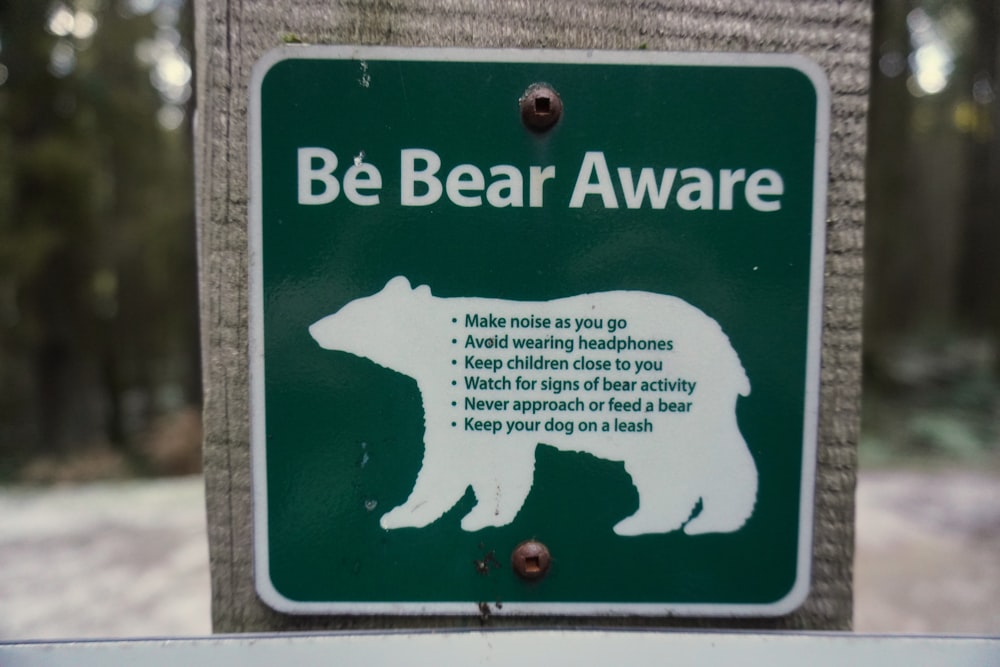 a bear warning sign posted on a pole
