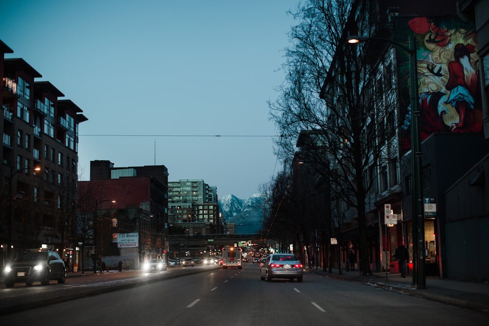 a car driving down a street next to tall buildings