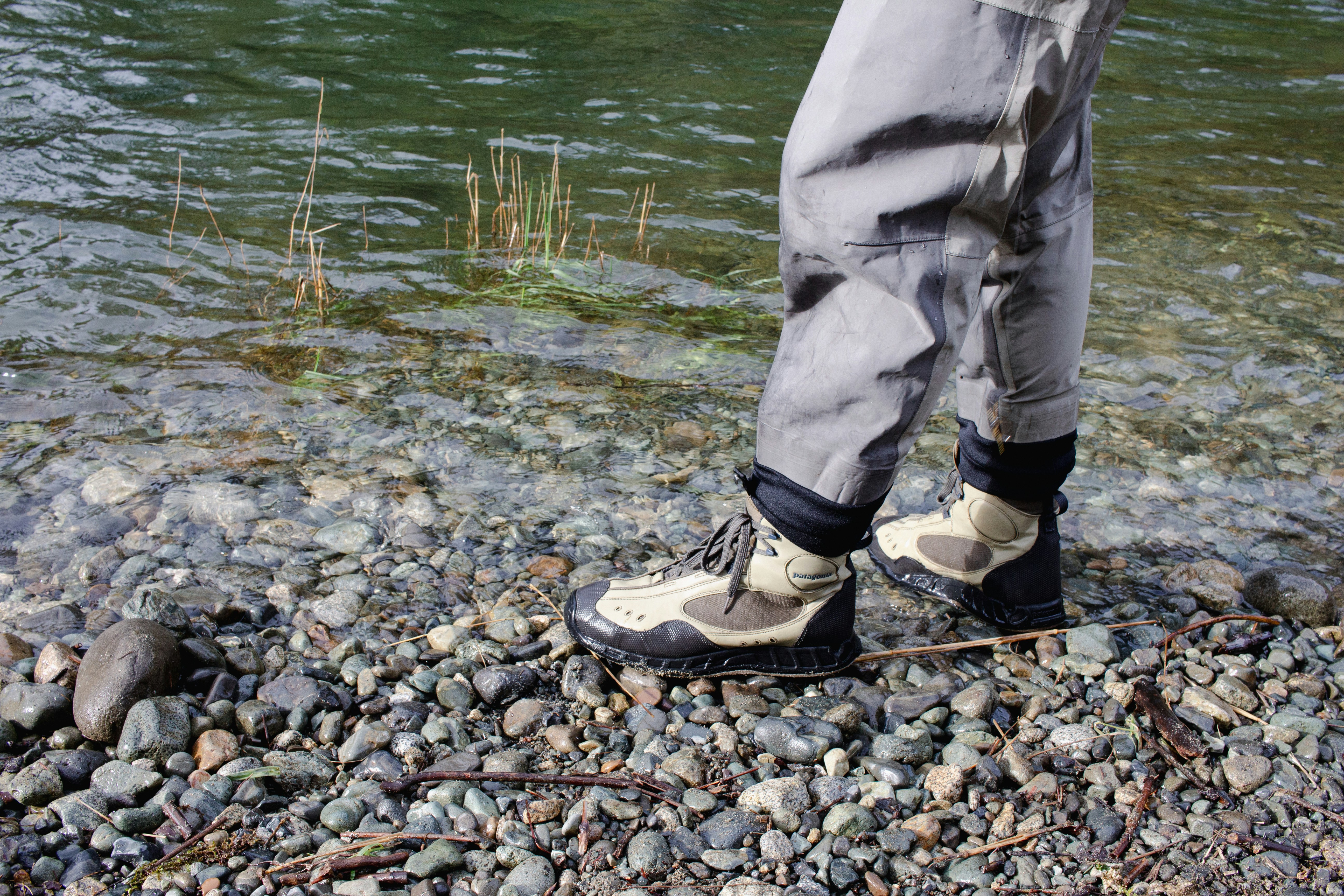 Angler in wading gear along a river bank.