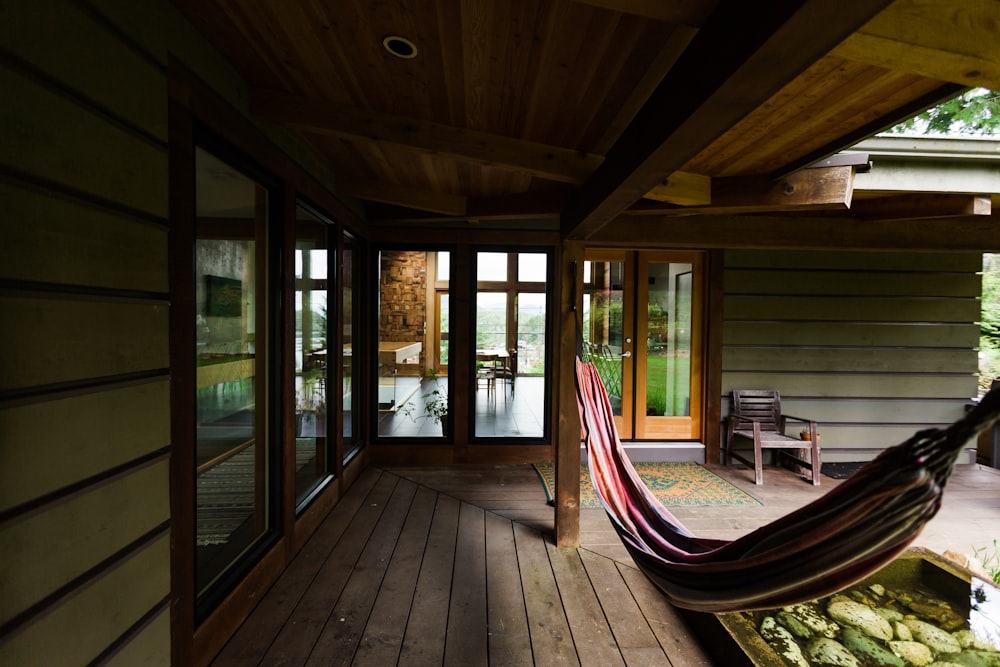 a hammock hanging from a wooden porch