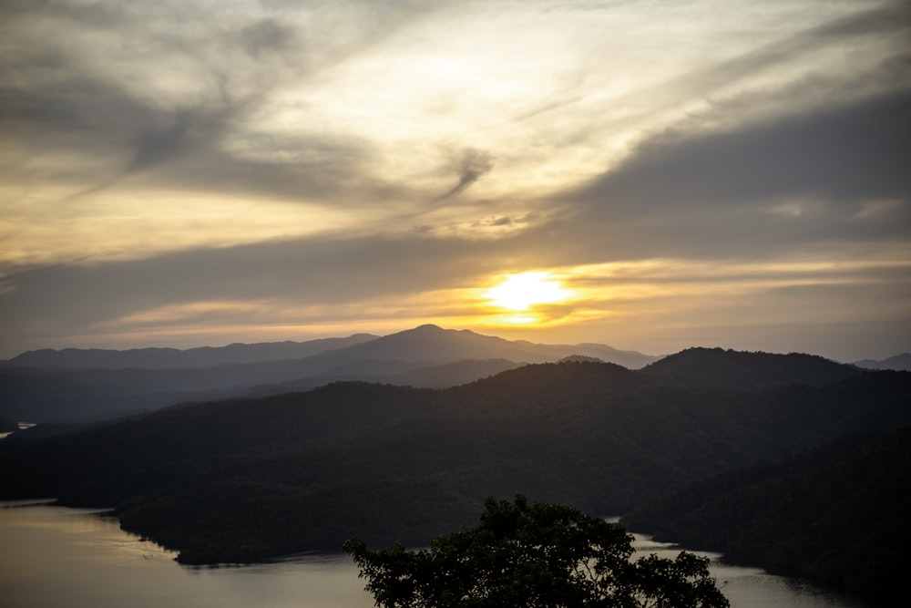 the sun is setting over a mountain range