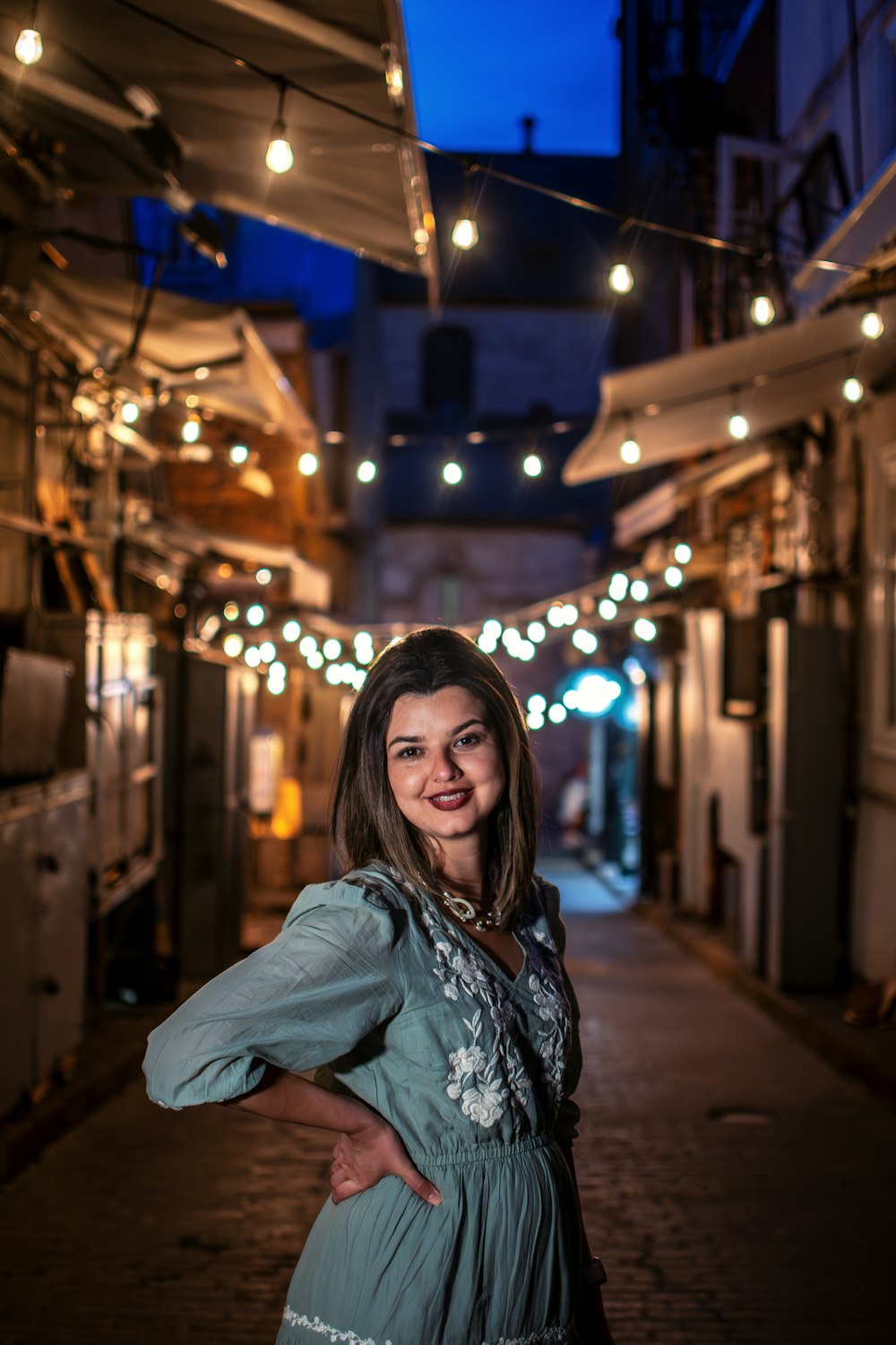 a woman standing in an alley way at night