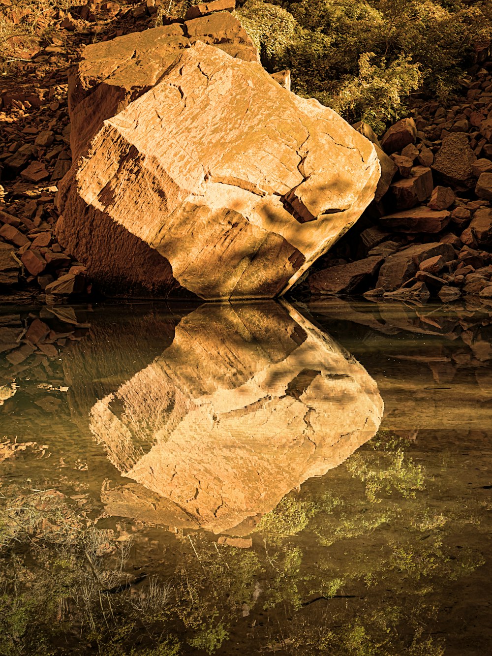 a large rock sitting in the middle of a body of water
