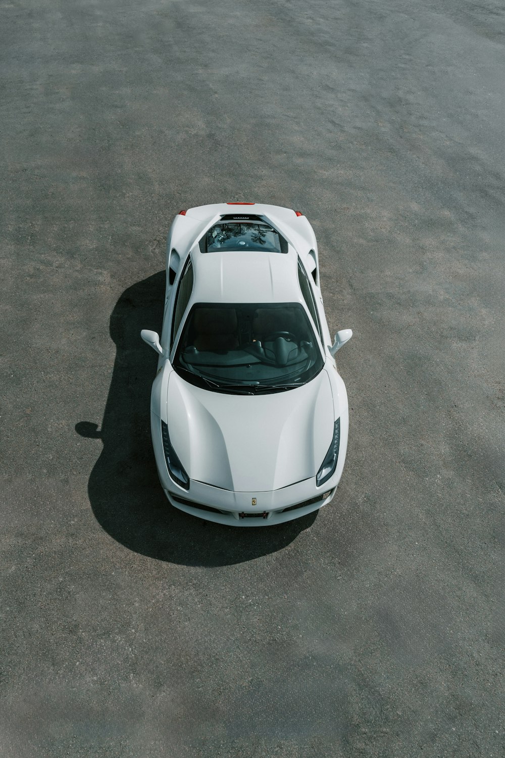 a white sports car parked in a parking lot