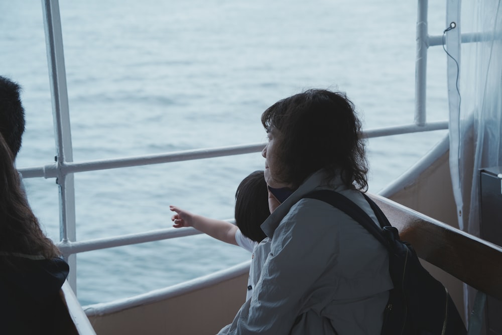 a woman standing on a boat looking out at the water