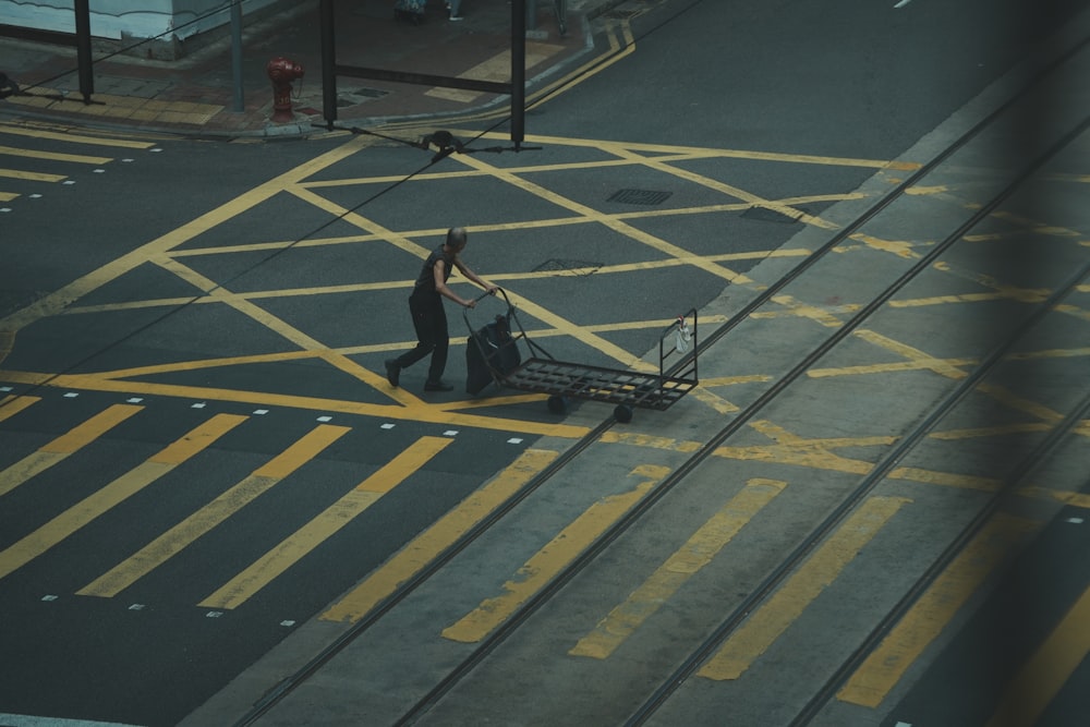 a person pushing a luggage cart down a street