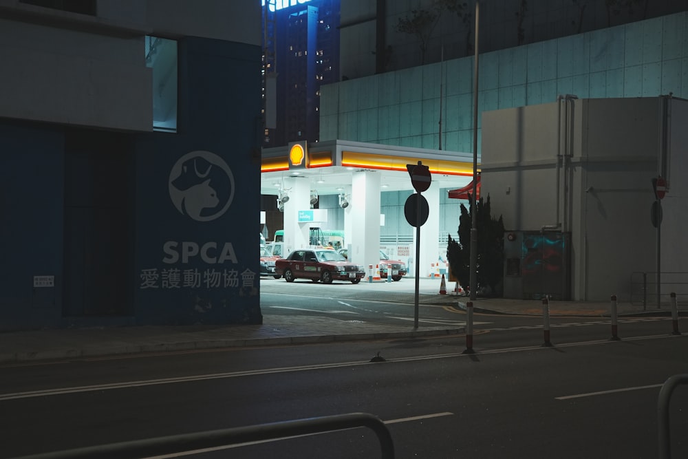 a city street at night with cars parked on the side of the road