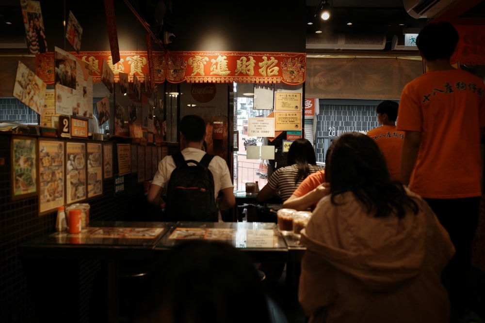 a group of people standing at a counter in a restaurant