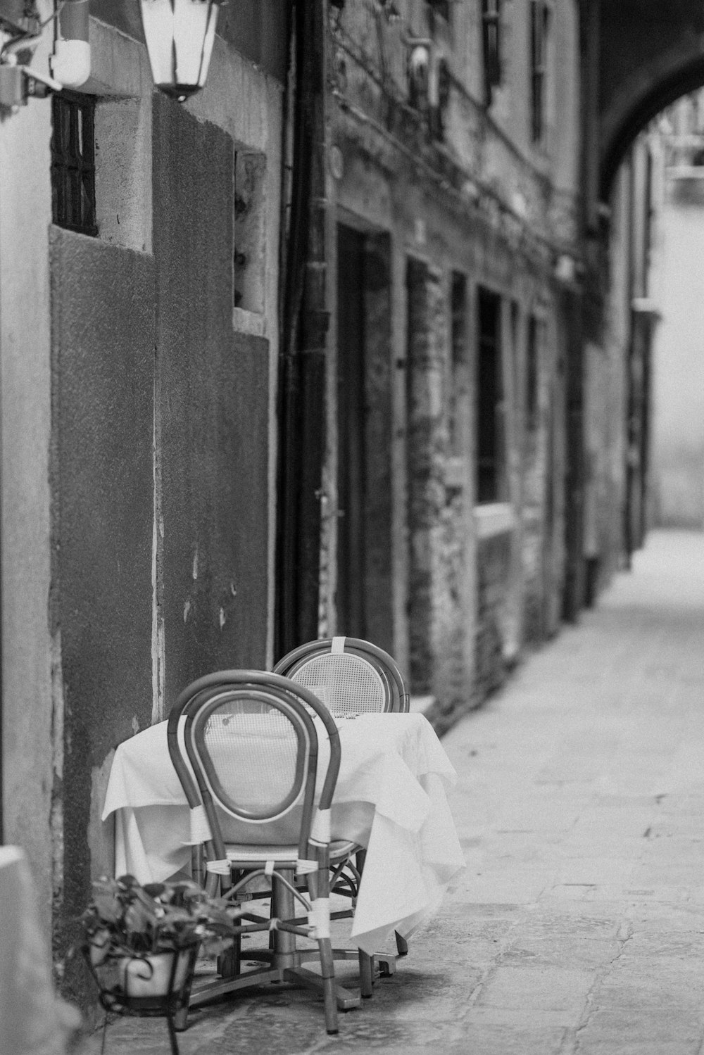 a chair sitting on the side of a street next to a table