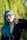 a woman with green hair and black glasses