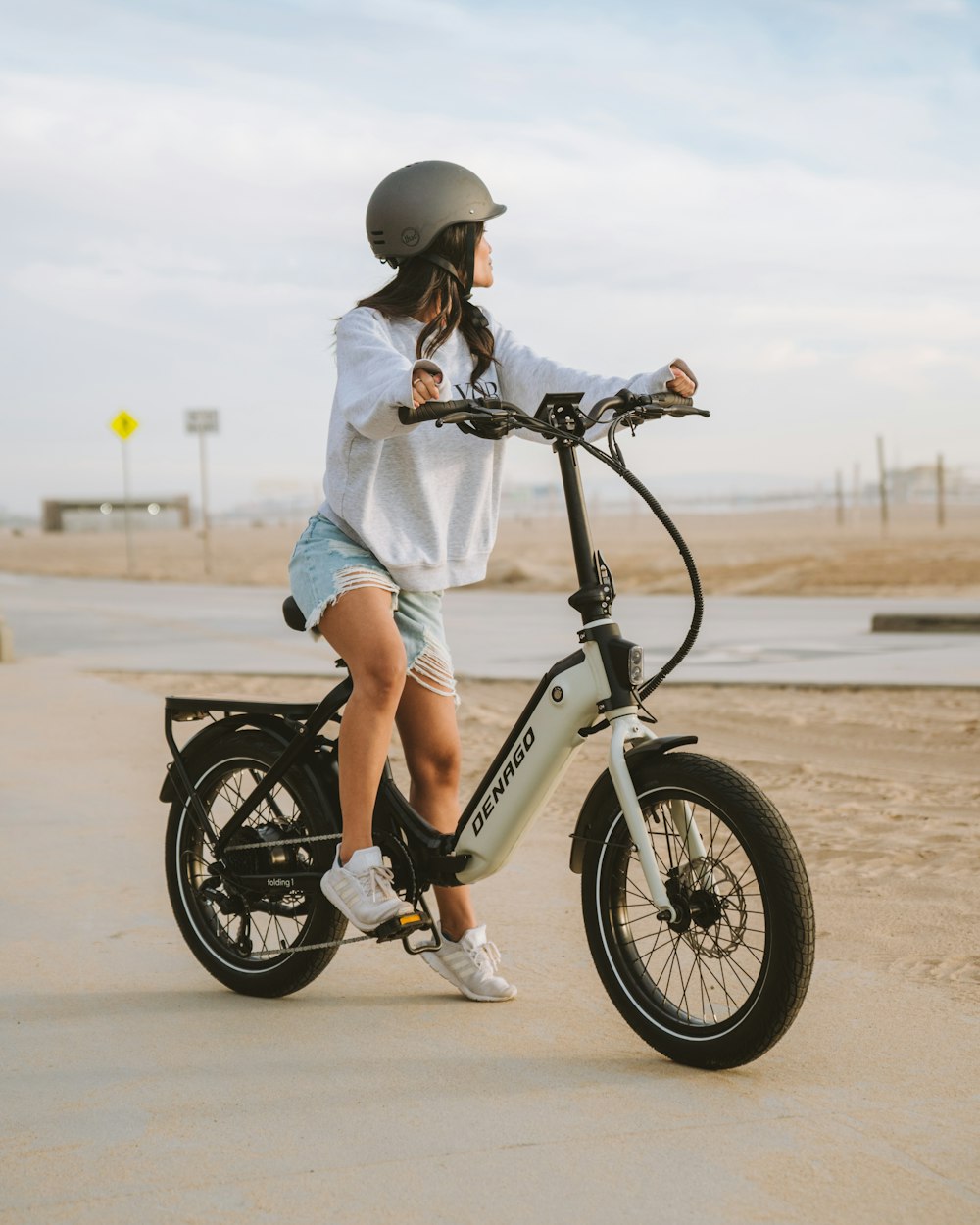 a woman riding a bike on the beach