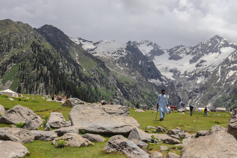 a man standing on top of a lush green hillside