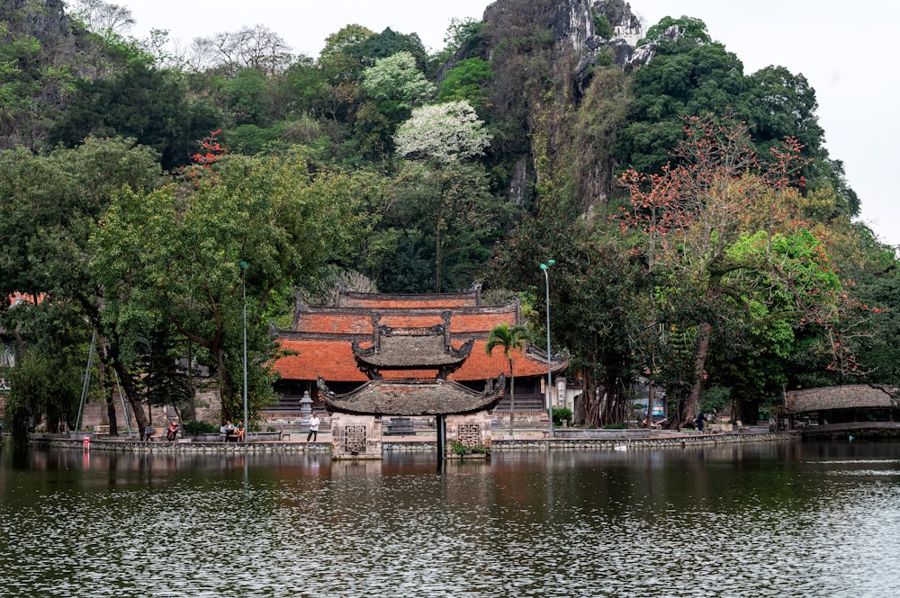 a building sitting on top of a lake next to a forest