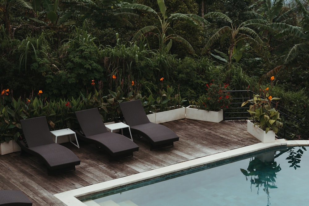 a swimming pool with lounge chairs next to it