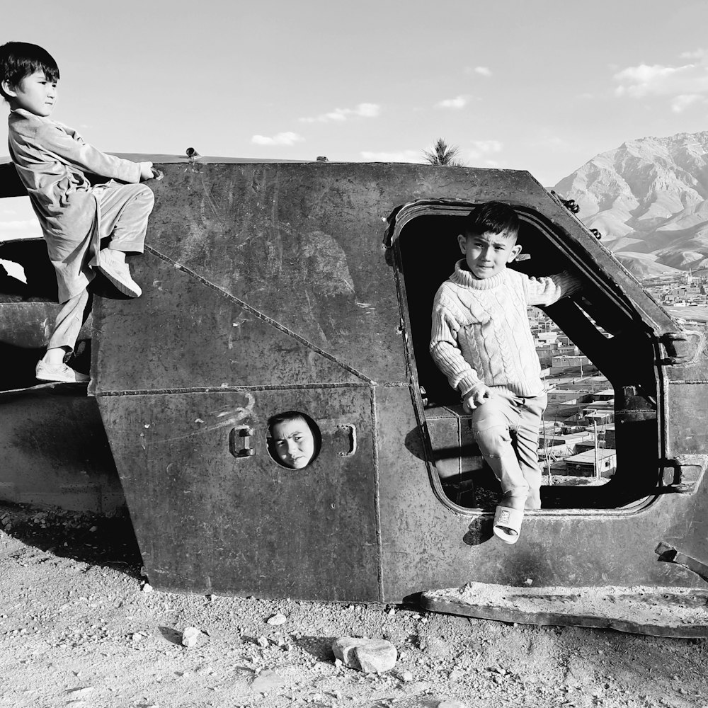 a couple of kids sitting on top of a helicopter