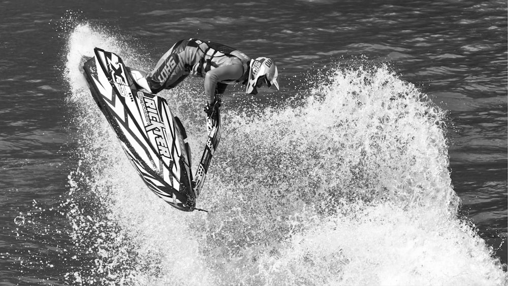 un uomo che cavalca un'onda in cima a una tavola da surf