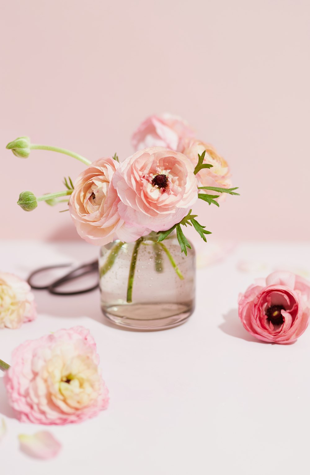 テーブルの上にピンクの花が咲き乱れる花瓶