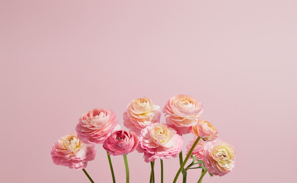 a vase filled with pink and yellow flowers