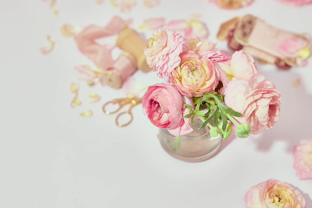 eine Vase gefüllt mit rosa Blumen auf einem Tisch