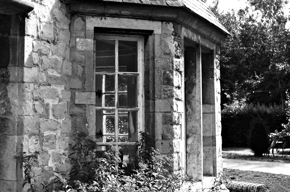 a black and white photo of a window in a stone building