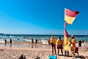 a group of people standing on top of a sandy beach