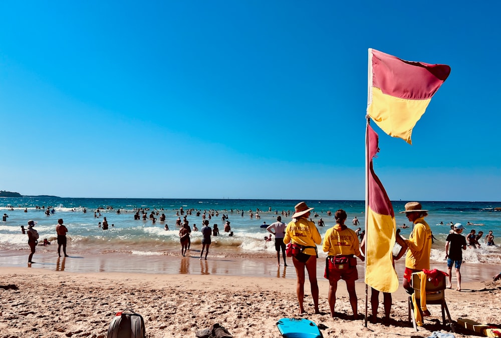 a group of people standing on top of a sandy beach