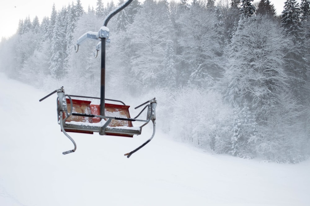 a ski lift with a snow covered forest in the background