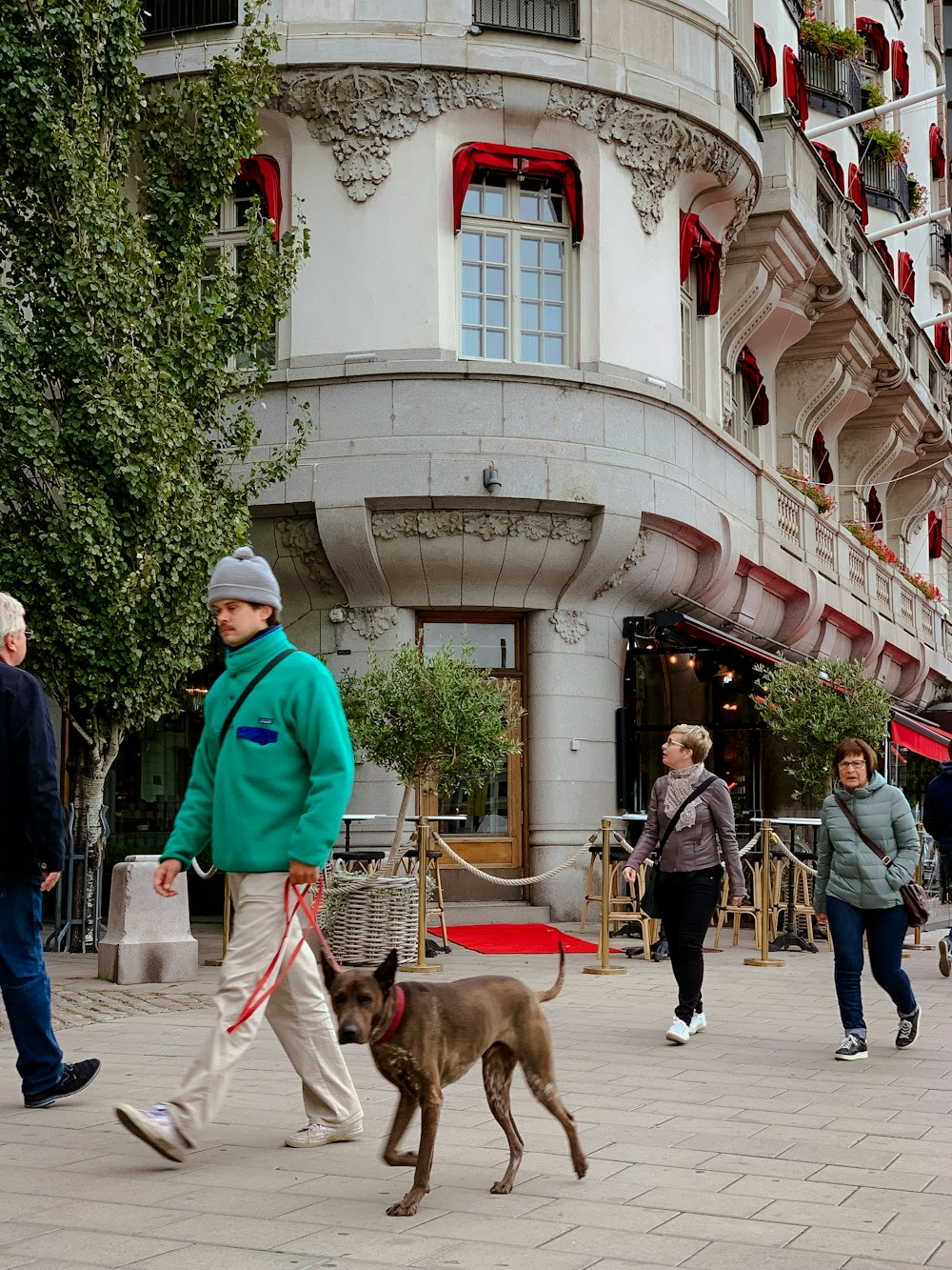 a man walking a dog down a sidewalk