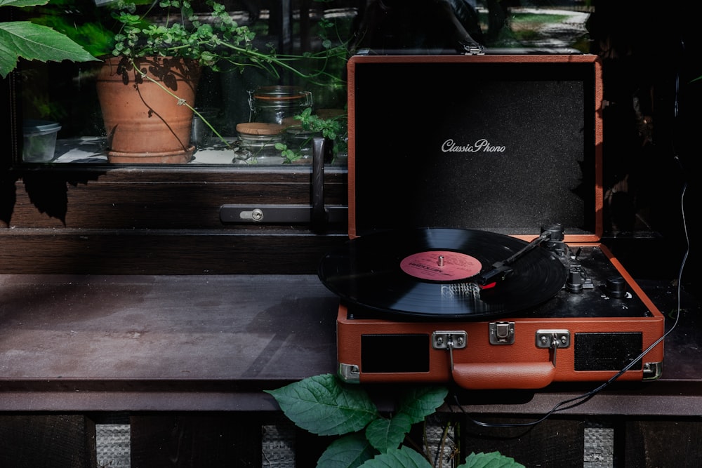 an old record player sitting on top of a suitcase