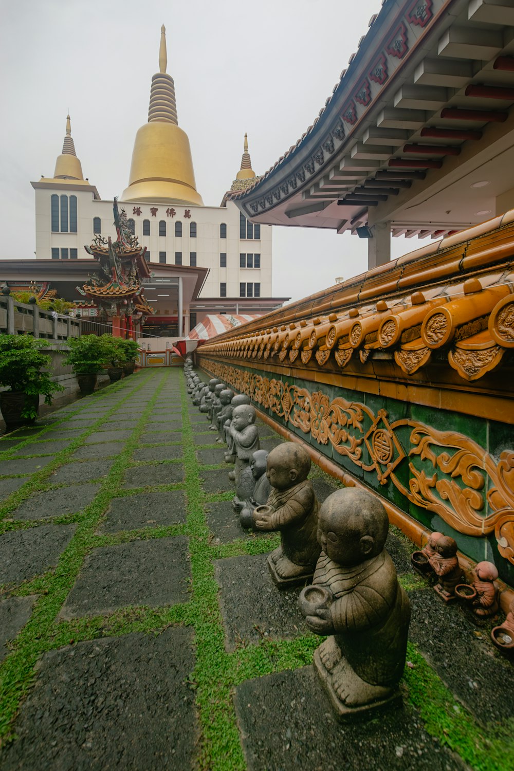 a row of statues sitting on top of a lush green field