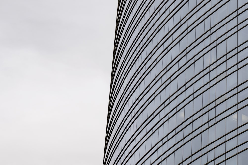 a plane flying in the air next to a tall building