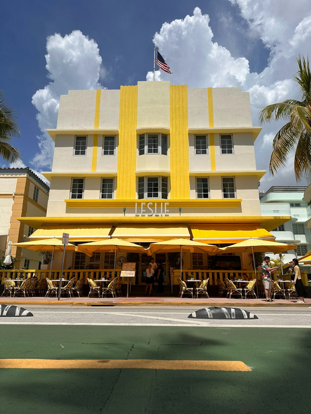 Un edificio amarillo y blanco con una bandera en la parte superior