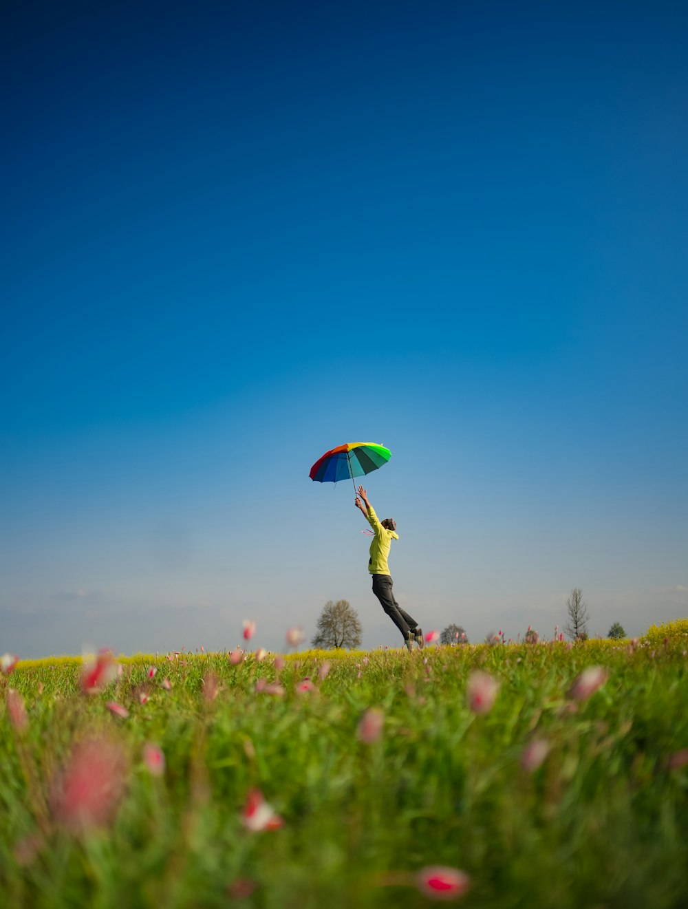 a person jumping in the air while holding a kite