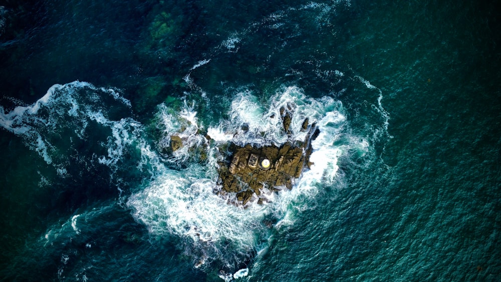 an aerial view of a rock formation in the ocean