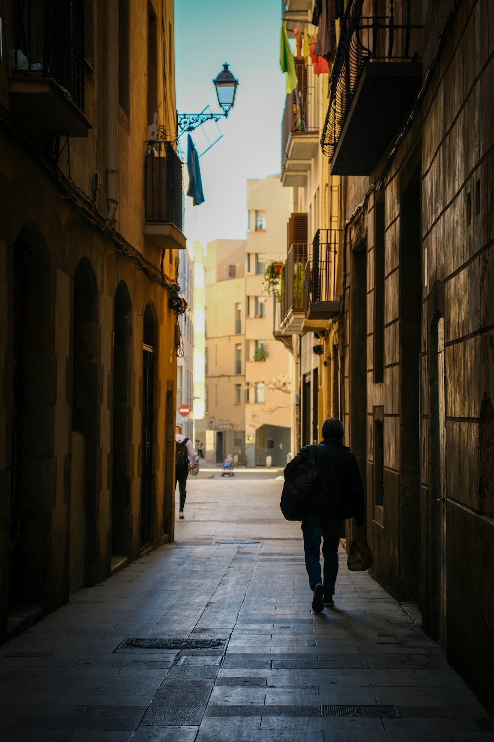 a person walking down a narrow alley way