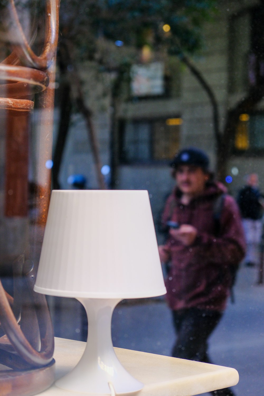 a lamp sitting on top of a table next to a window