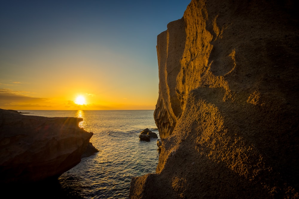 El sol se está poniendo sobre el océano desde un acantilado