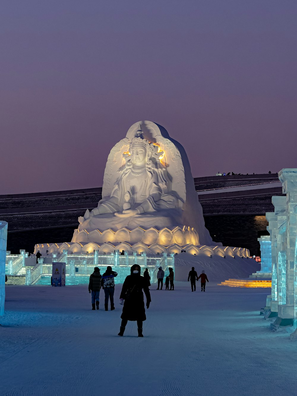 a group of people standing around a snow sculpture