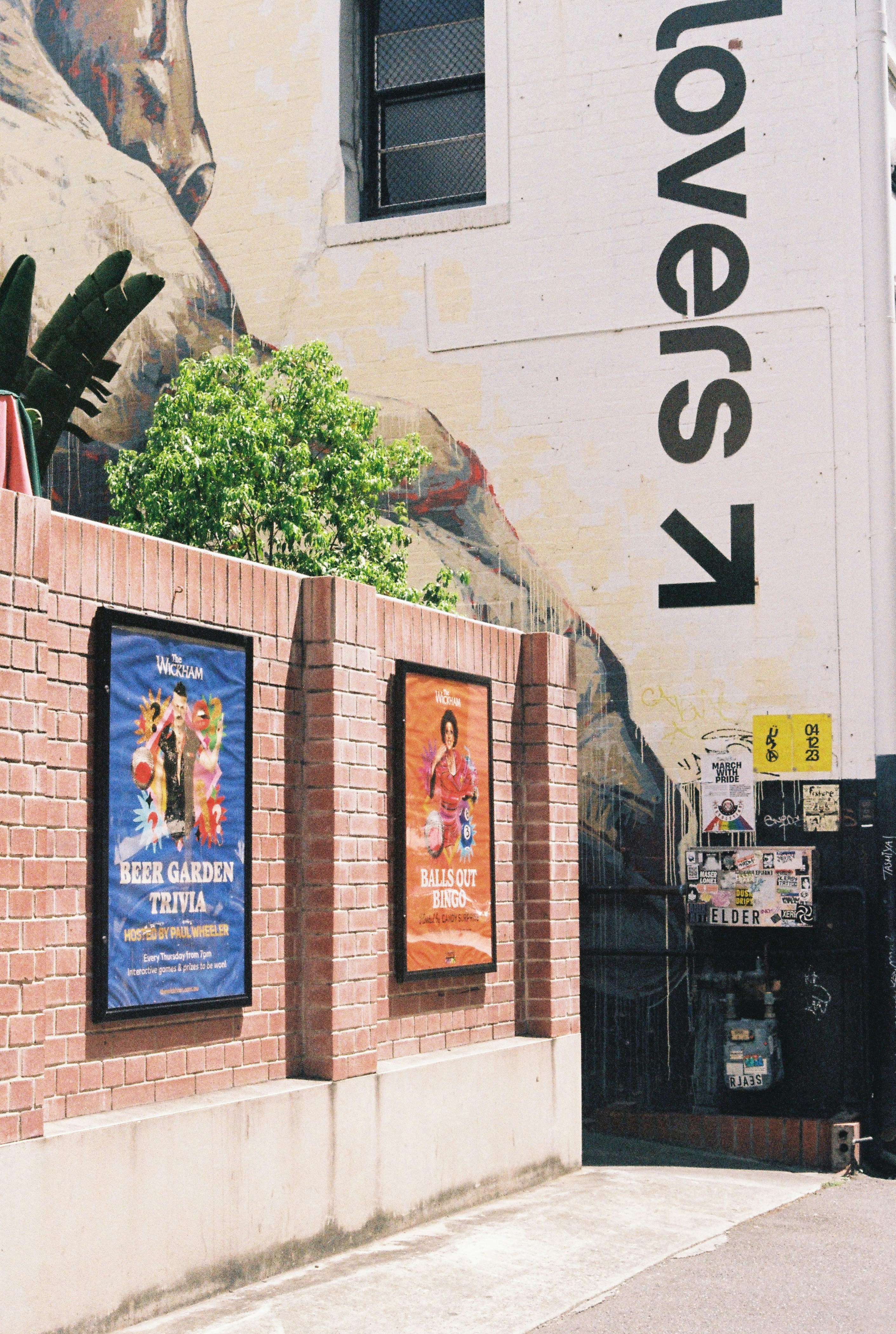 a brick wall with posters on it next to a building