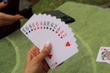 a person holding four of a kind of playing cards
