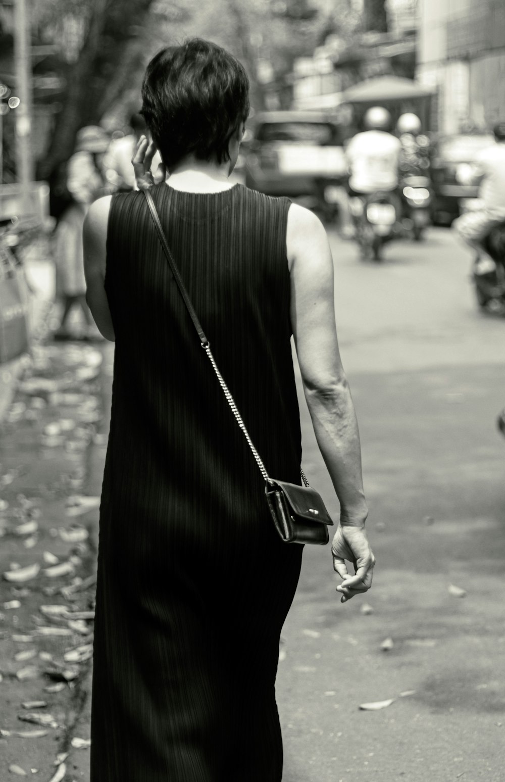 a woman walking down a street while talking on a cell phone