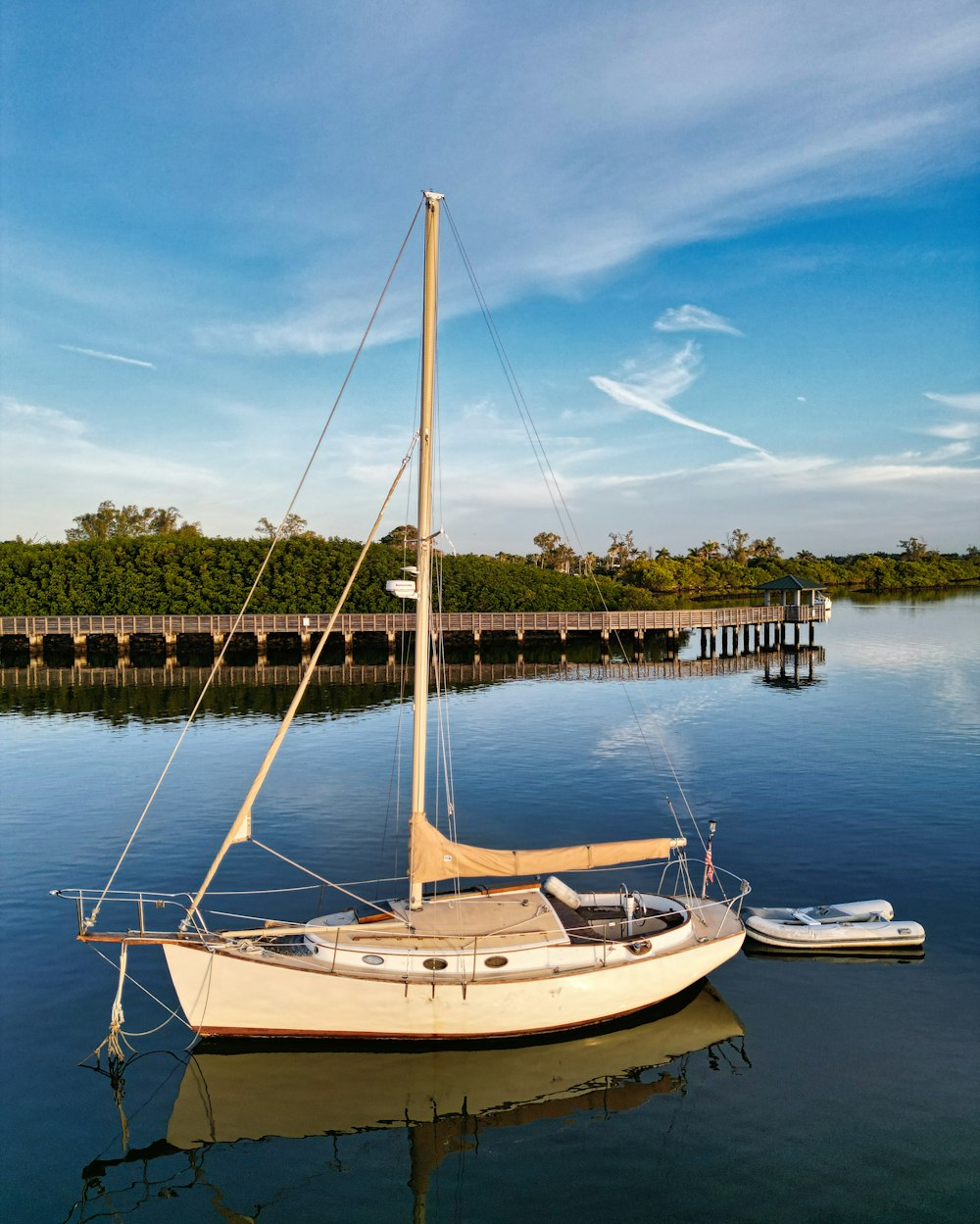 a sailboat sits in the water next to a dock