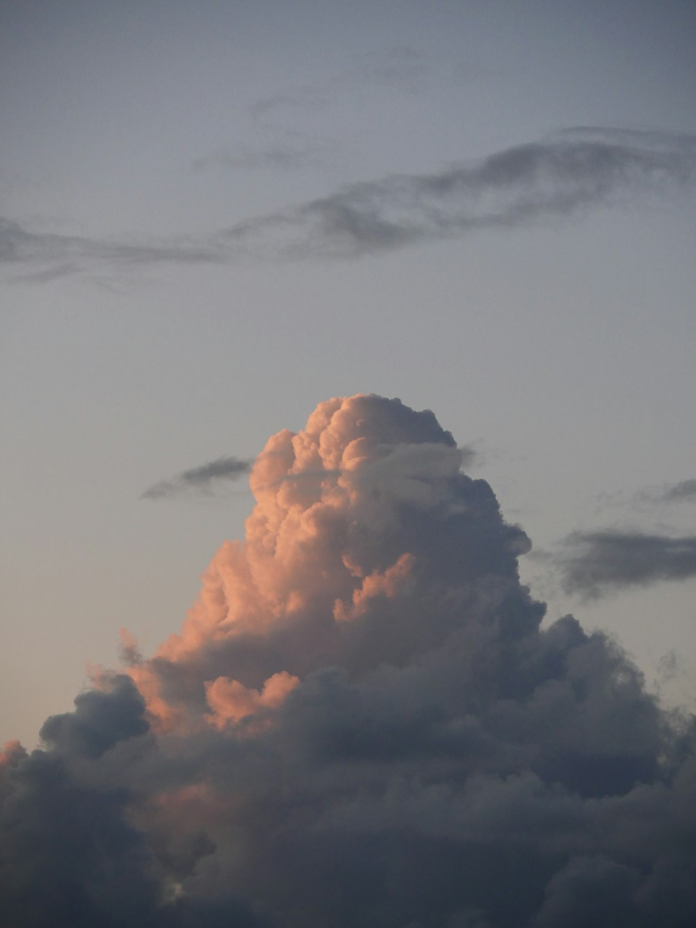 a plane flying in the sky with a cloud in the background