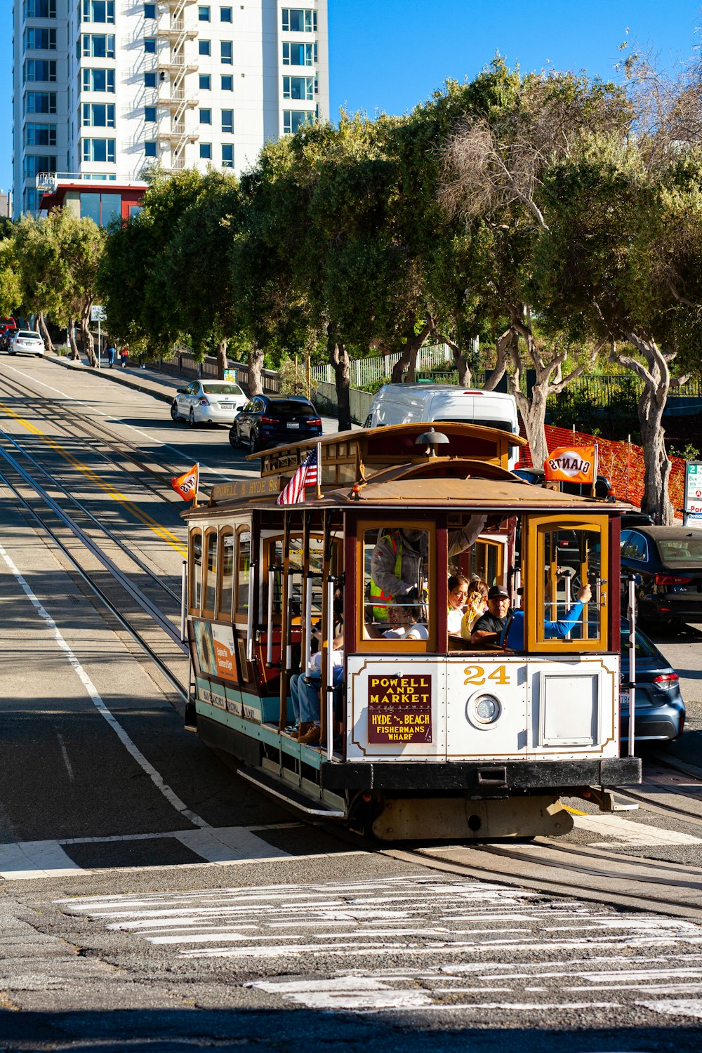 a cable car traveling down a street next to tall buildings